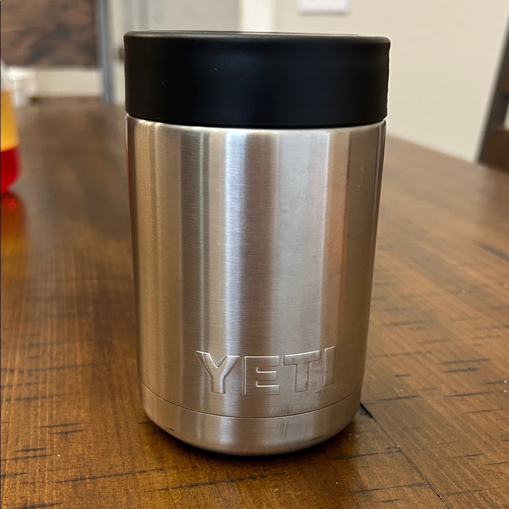 YETI Silver koozie with Black Lid. Dings on bottom.